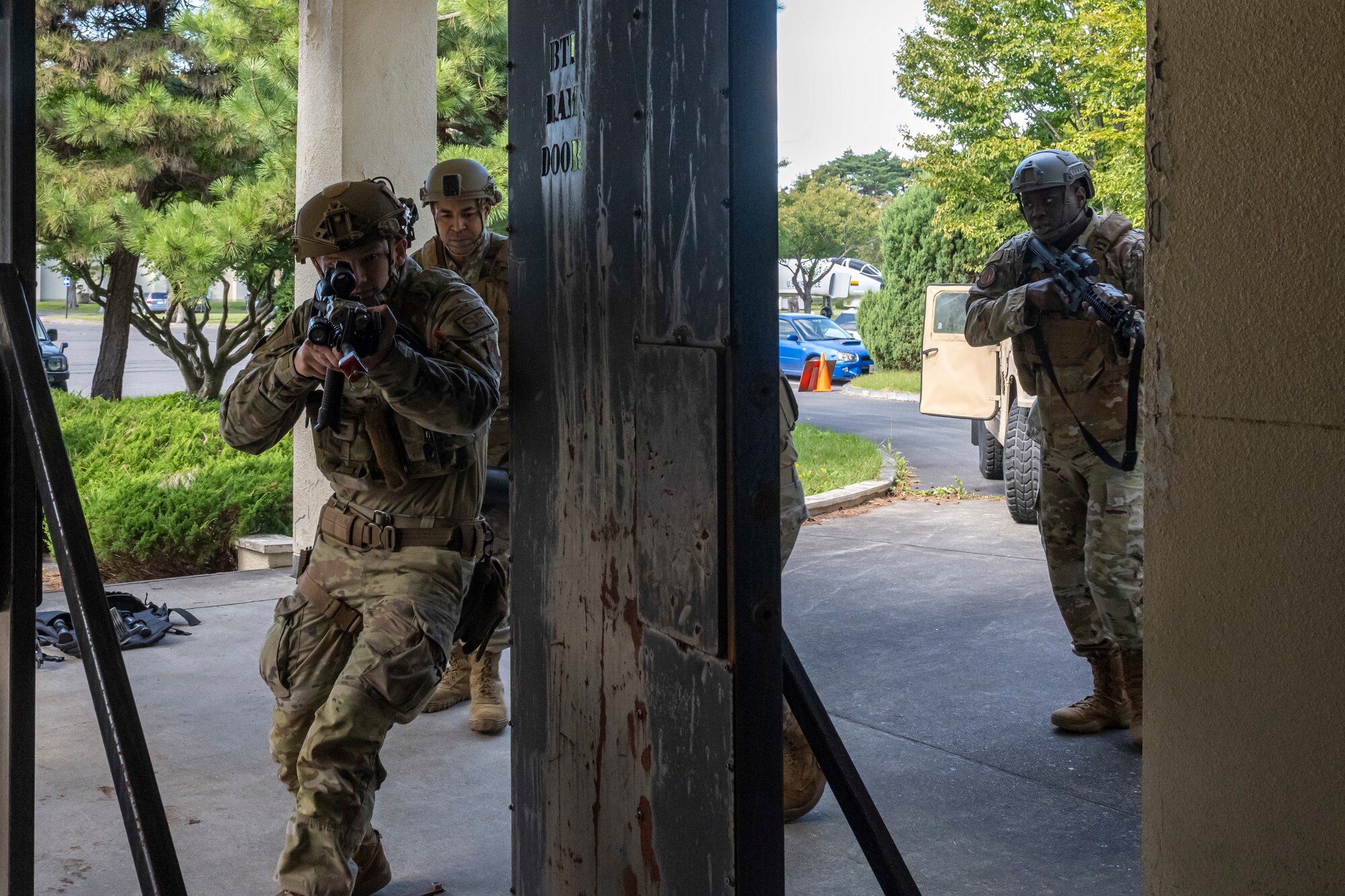 Airmen run through a door threshold.