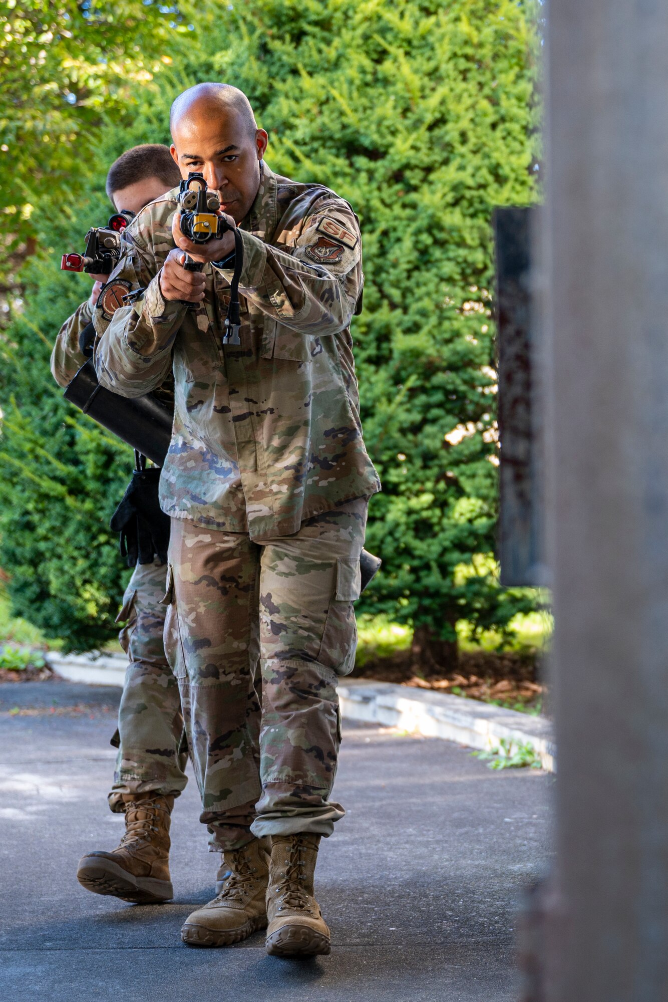 Airmen approach a simulated breaching door during training.