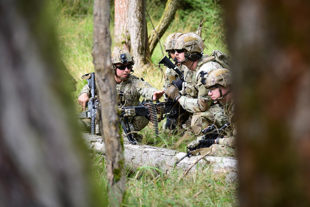 A senior soldier directs his troops while conducting a scout section live- fire exercise.