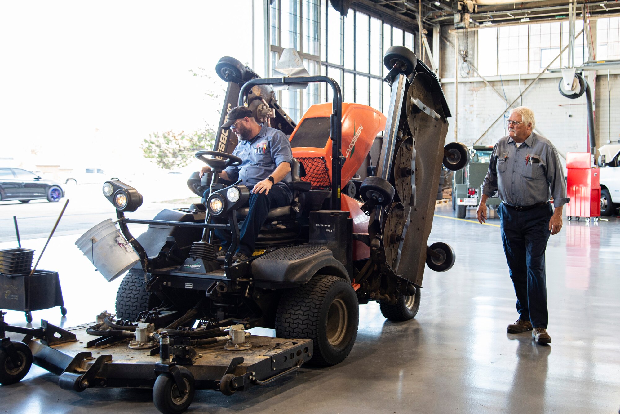 Mechanics inspect lawn mower.
