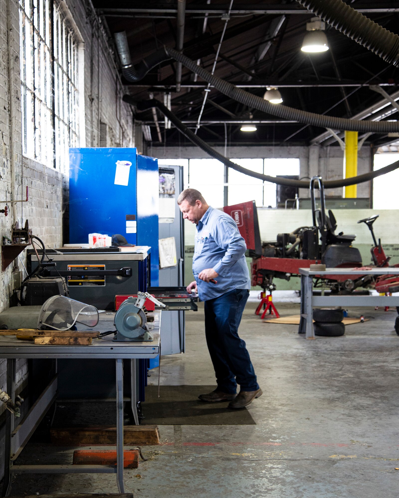 Mechanic stands at tool bench.