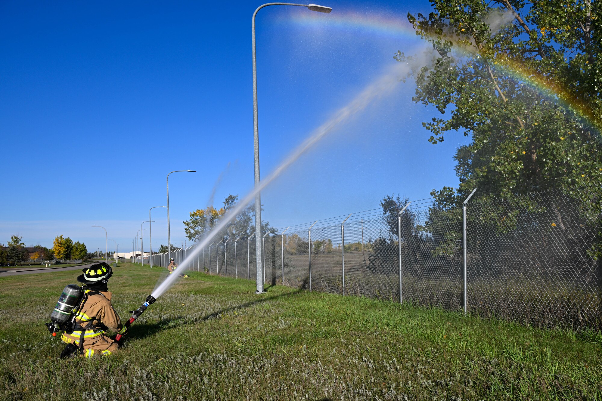 Airman 1st Class Cole Burchfield, 5th Civil Engineer Squadron firefighter, discharges a fire hose during a National Fire Protection Association (NFPA) 1410 drill at Minot Air Force Base, North Dakota, Oct. 4, 2023. Burchfield and other Team Minot firefighters conducted readiness exercises as part of National Fire Prevention Week. (U.S. Air Force photo by Airman 1st Class Kyle Wilson)