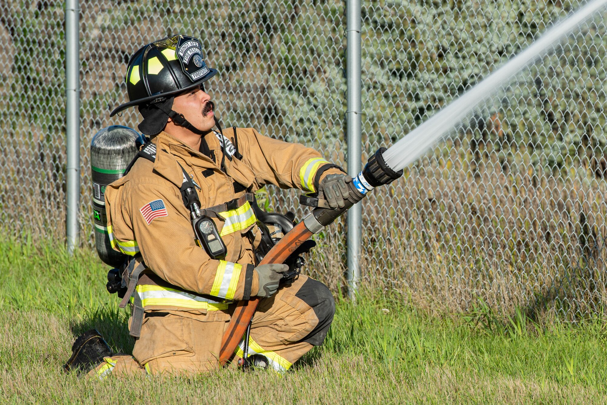 Senior Airman Brandon Valle, 5th Civil Engineer Squadron lead firefighter, discharges a fire hose during a National Fire Protection Association (NFPA) 1410 drill at Minot Air Force Base, North Dakota, Oct. 4, 2023. Team Minot’s firefighters regularly perform drills like the NFPA 1410 to ensure they are prepared to respond in the event of fire emergency situations. (U.S. Air Force photo by Airman 1st Class Kyle Wilson)