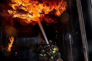 Staff Sgt. Alex Urrutia, 99th Civil Engineering Squadron lead fire protection specialist, extinguishes a fire during structural fire