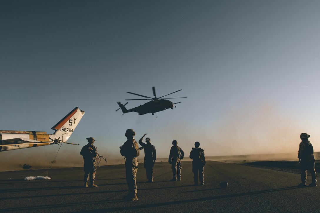 U.S. Marines attached to 8th Engineer Support Battalion, Combat Logistics Regiment 27, 2nd Marine Logistics Group, signal to a CH-53E Super Stallion to land while conducting helicopter support team operations during Weapons and Tactics Instructor (WTI) course 1-24 in Yuma, Arizona, Oct. 3, 2023. WTI 1-24 is an advanced seven-week course, which provides standardized tactical training and incorporates Marine Corps planning and implementation of air and ground tactics through a series of escalating evolutions, to support Marine aviation training and readiness. (U.S. Marine Corps photo by Cpl. Meshaq Hylton)