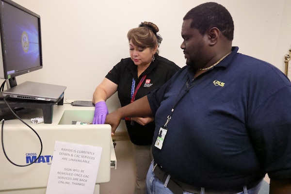 Rosario Swafford, U.S. Army Corps of Engineers, Mobile District Personnel Security Specialist, takes the fingerprints of a customer in the Mobile District Security Office, Mobile, Alabama, October 10, 2023. Swafford said the important thing she learned from her family growing up was treating others with dignity and respect and helping those who couldn’t help themselves. (U.S. Army photo by Chuck Walker)