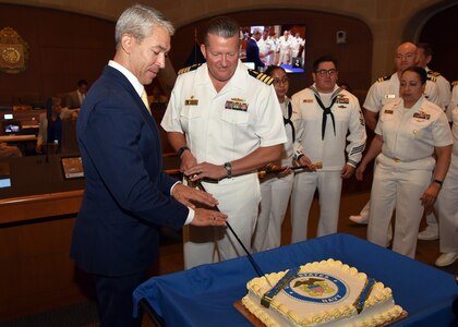 Capt. Walter Brafford, commander, Naval Medical Forces Support Command (NMFSC) and director, U.S. Navy Dental Corps, assisted by San Antonio Mayor Ron Nirenberg, cuts a cake in recognition of the U.S. Navy’s 248th birthday during a City Council Session held at the Municipal Plaza. Joining Brafford at the session were Sailors from NMFSC, Naval Medical Research Unit (NAMRU) San Antonio, Navy Talent Acquisition Group (NTAG) San Antonio, and Navy veterans. (U.S. Navy photo by Burrell Parmer, NAMRU San Antonio Public Affairs/Released)