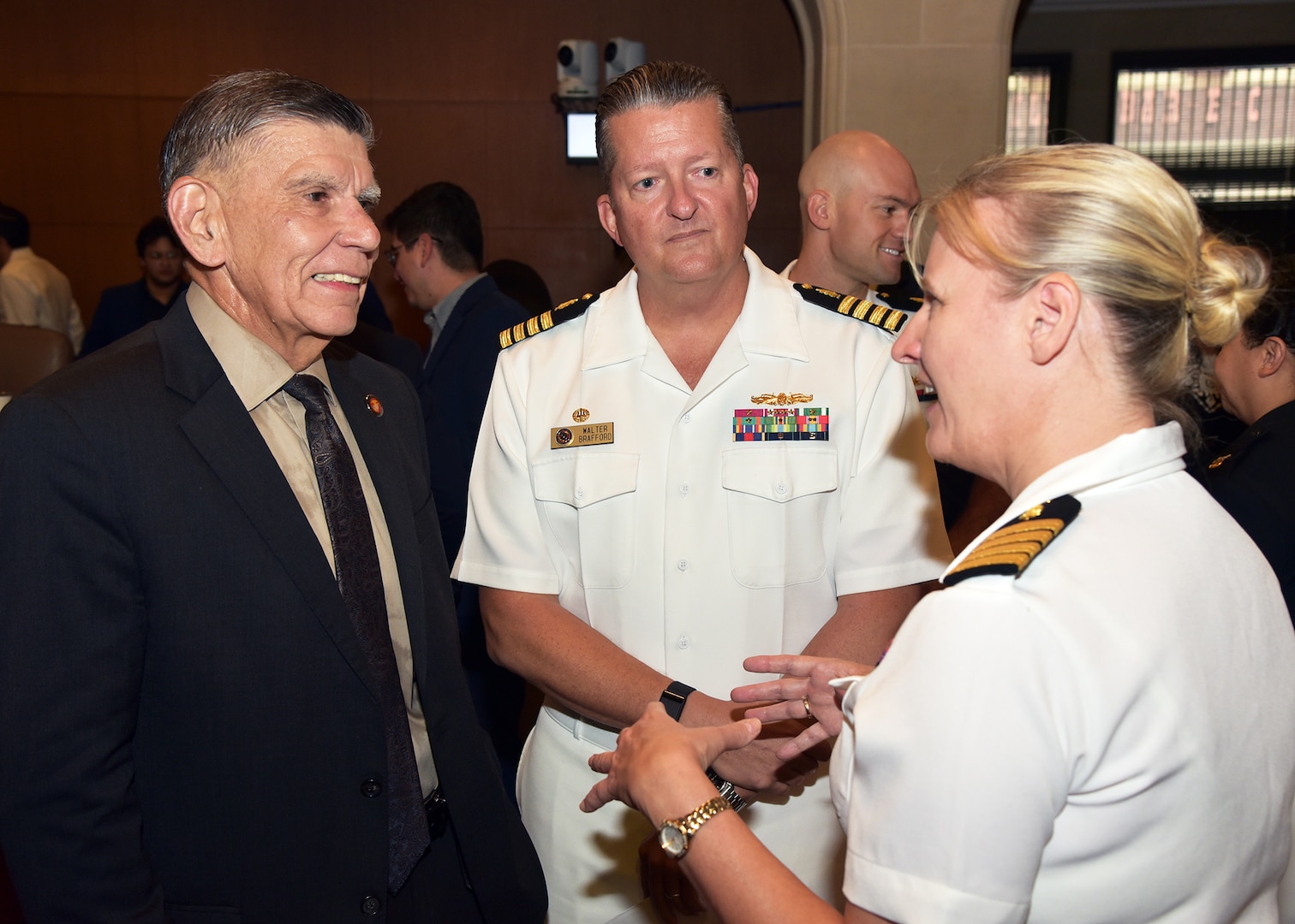 SAN ANTONIO – (Oct. 12, 2023) – Capt. Jennifer Buechel, commanding officer, Naval Medical Research Unit (NAMRU) San Antonio, joined by Capt. Walter Brafford, commander, Naval Medical Forces Support Command (NMFSC) and director, U.S. Navy Dental Corps, speaks with retired Marine Maj. Gen. Juan Ayala, director, Military and Veteran Affairs Department for the City of San Antonio prior to the start of a City Council Session which honored the U.S. Navy’s 248th birthday with a cake-cutting ceremony. (U.S. Navy photo by Burrell Parmer, NAMRU San Antonio Public Affairs/Released)