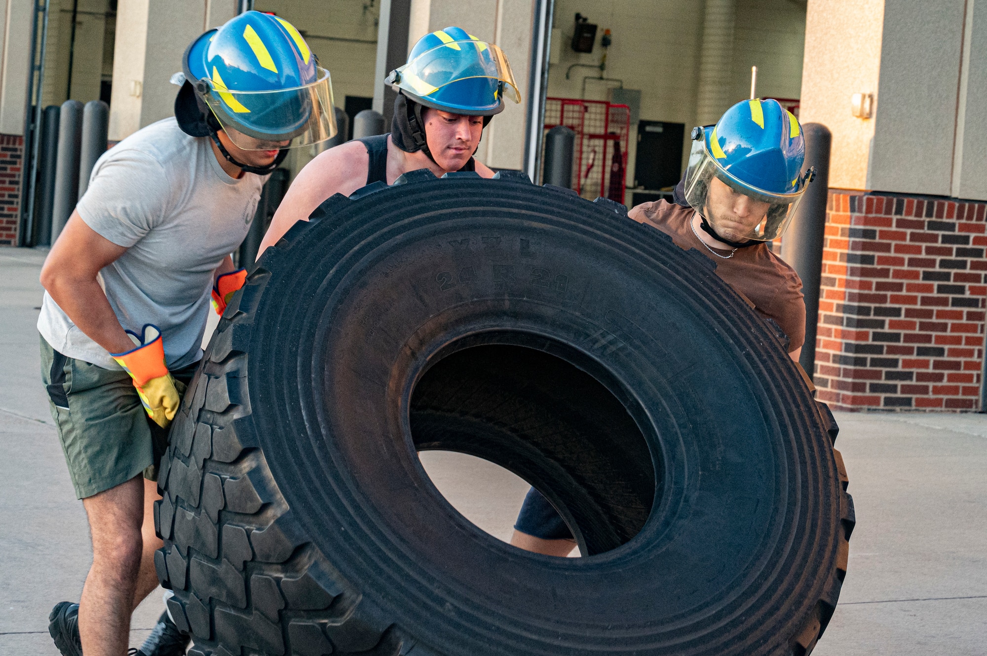 Airmen from the 7th Civil Engineer Squadron flip a truck tire at Dyess Air Force Base, Texas, Oct. 11, 2023. The fire department organized a fire muster competition celebrating Fire Prevention Week demonstrating skills used by firefighters. (U.S. Air Force photo by Airman 1st Class Alondra Cristobal Hernandez)