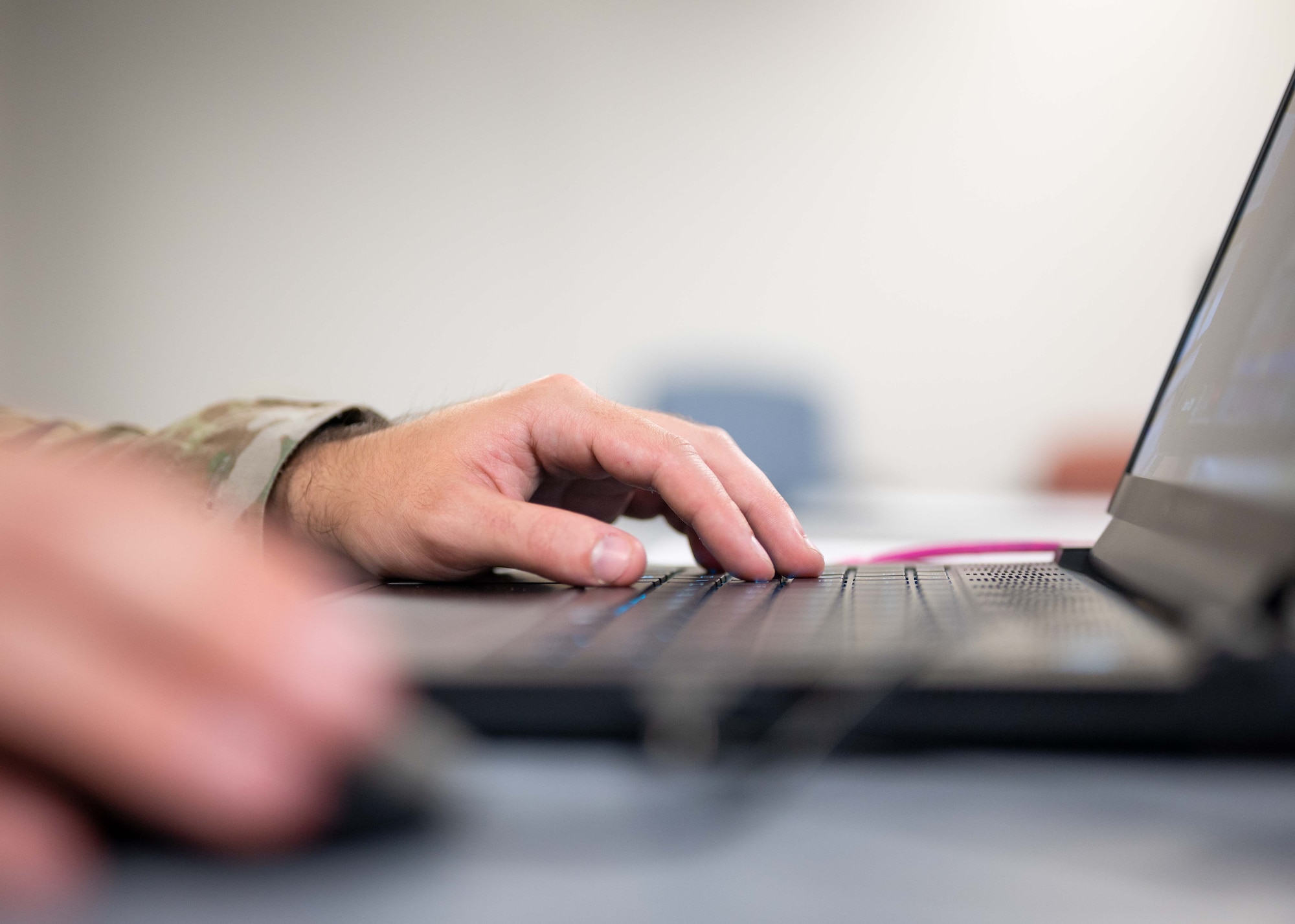 A players hands presses keys on a keyboard.