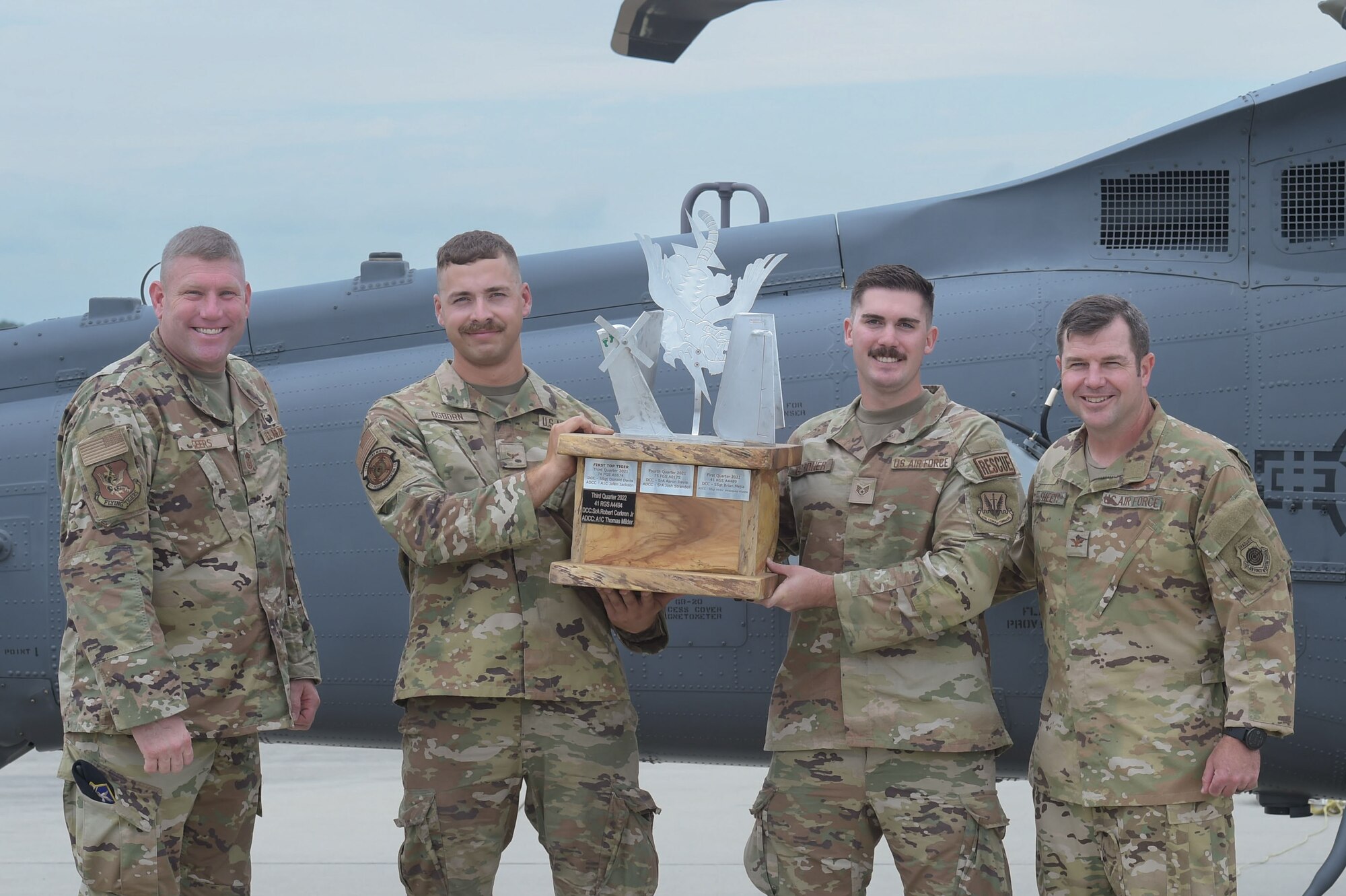 U.S. Air Force Col. Paul Sheets, 23rd Wing commander, far right, and U.S. Air Force Chief Master Sgt. Justin Geers, 23rd Wing command chief, pose for a group photo with the winners of the Top Tiger Competition, Staff Sgt. Ryan Gardner, inner right and Airman 1st Class David Osborn, inner left, from the 41st Rescue Generation Squadron at Moody Air Force Base, Georgia, Oct. 6, 2023. The 41st RGS won the Top Tiger Competition for the third time in a row this year. (U.S. Air Force photo by Airman Cade Ellis)
