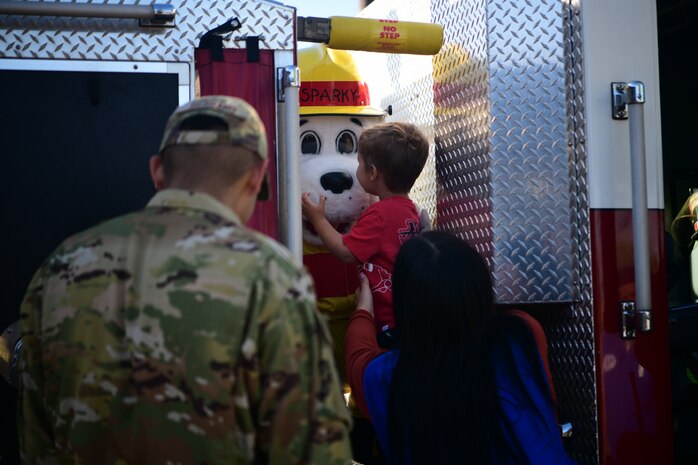 Sparky the fire dog greets a child at the Child Development Center (CDC) on Beale Air Force Base, California, Oct. 11, 2023.