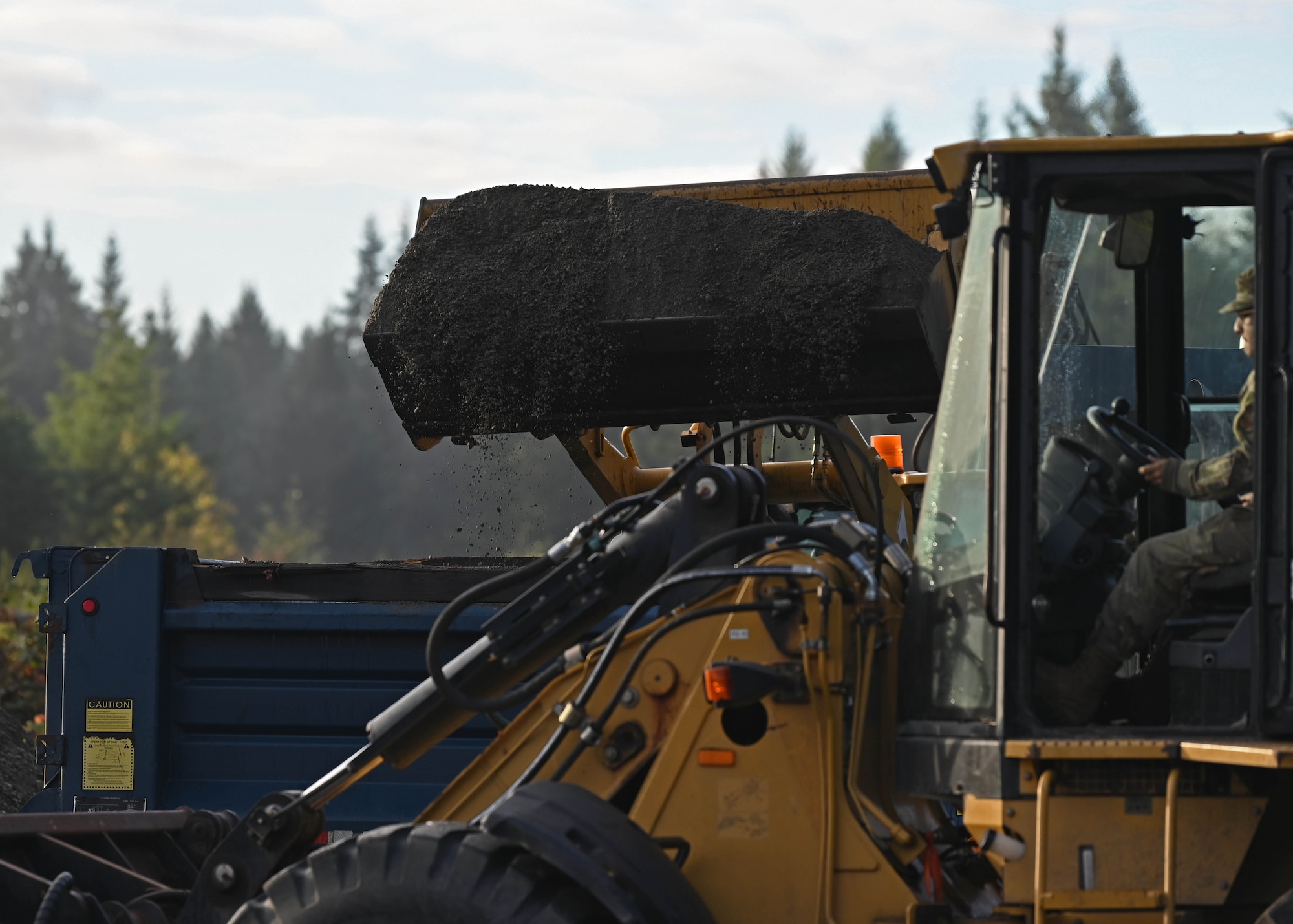 U.S. Air Force Airmen with the 627th Civil Engineer Squadron operate a front loader and a backhoe during a vehicle rodeo at Joint Base Lewis-McChord, Washington, Oct. 12, 2023. The 627th CES held a vehicle rodeo to license Airmen, so they can operate compact track loaders, backhoes, front end loaders, dump trucks, all terrain forklifts and street sweepers, ensuring multi-capable Airmen capabilities and mission readiness. (U.S. Air Force photo by Senior Airman Callie Norton)