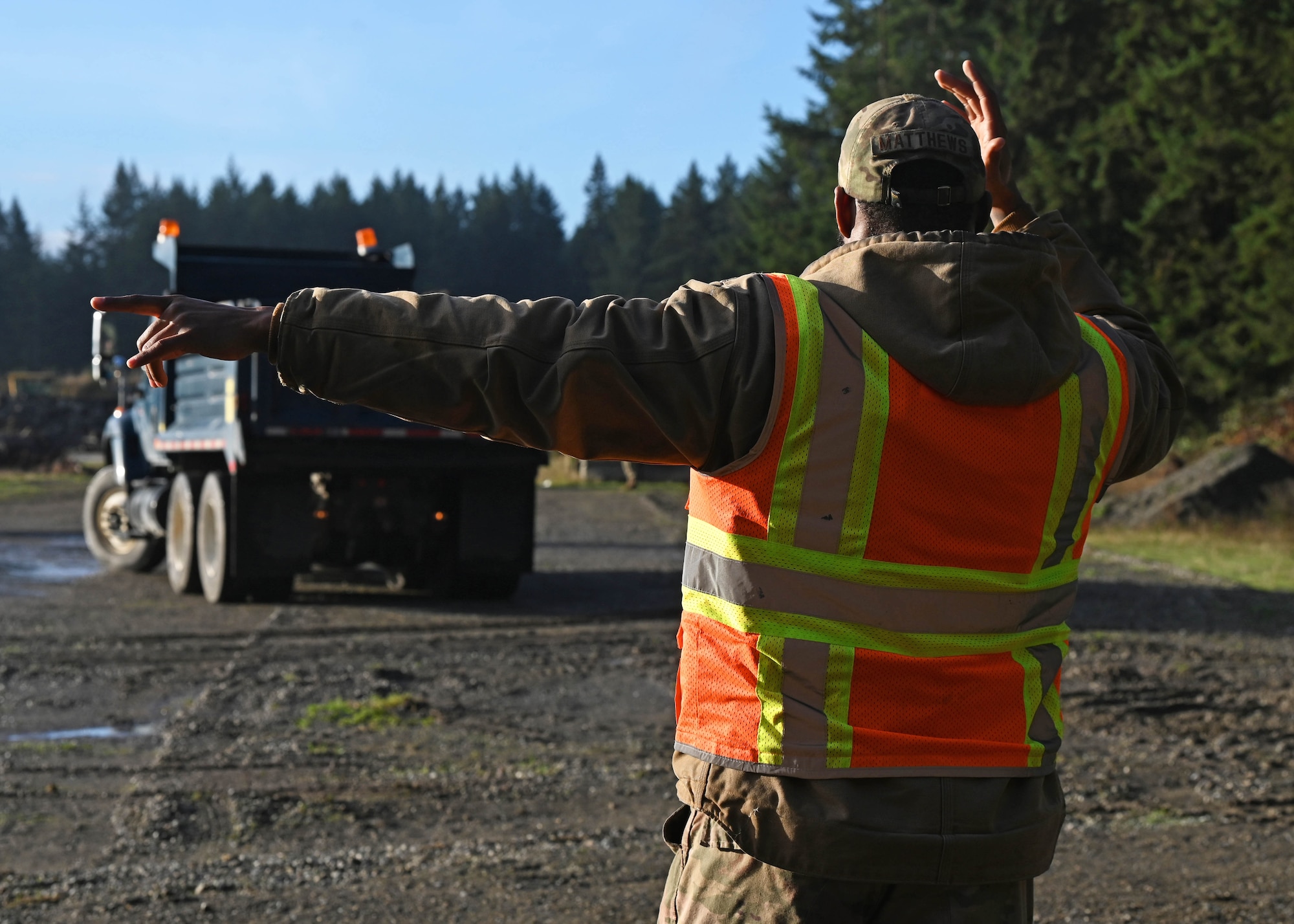 U.S. Air Force Staff Sgt. Irvin Matthews, a pavements and equipment journeyman with the 627th Civil Engineer Squadron, guides a dump truck during a vehicle rodeo at Joint Base Lewis-McChord, Washington, Oct. 12, 2023. The 627th CES held a vehicle rodeo to license Airmen, so they can operate compact track loaders, backhoes, front end loaders, dump trucks, all terrain forklifts and street sweepers, ensuring multi-capable Airmen capabilities and mission readiness. (U.S. Air Force photo by Senior Airman Callie Norton)