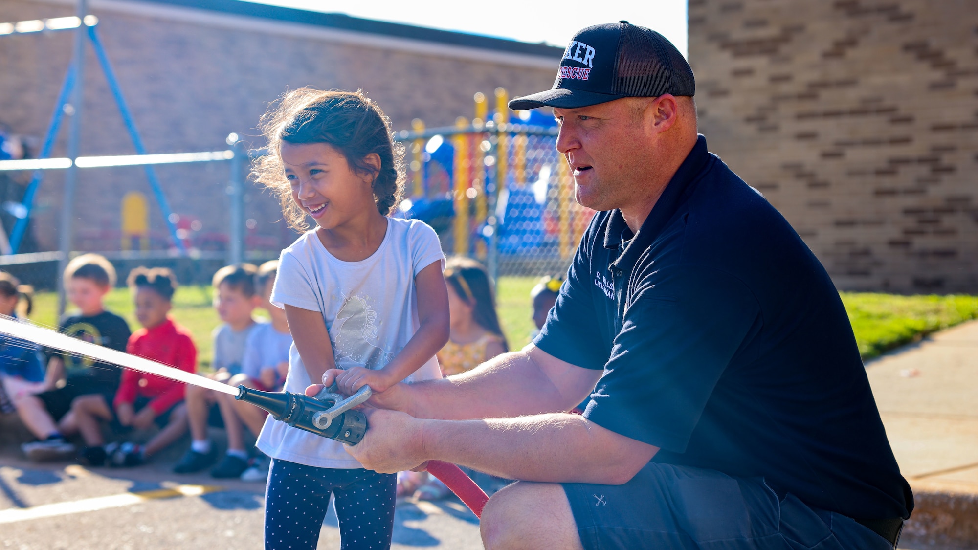 child holds fire hose