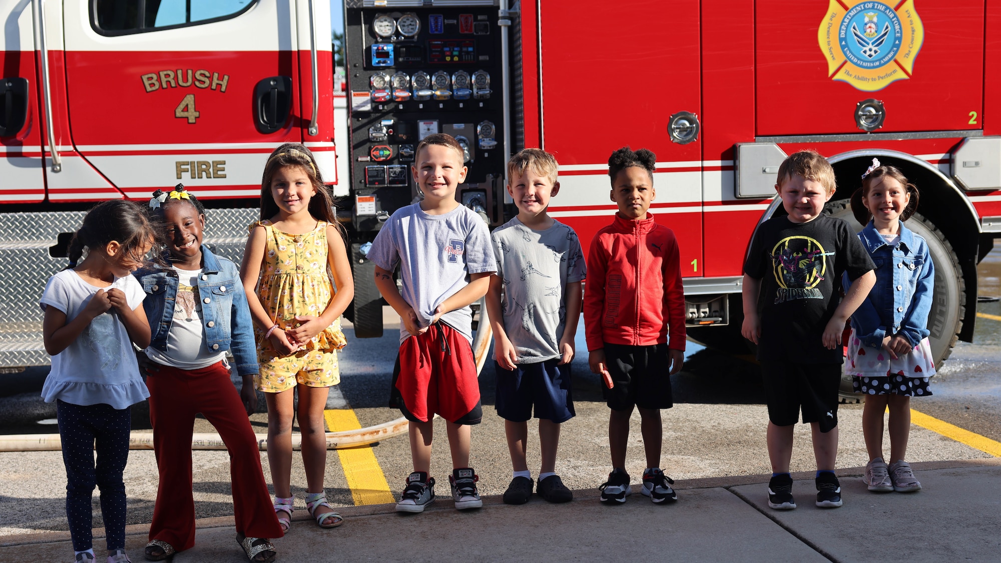 children pose for photo by fire truck