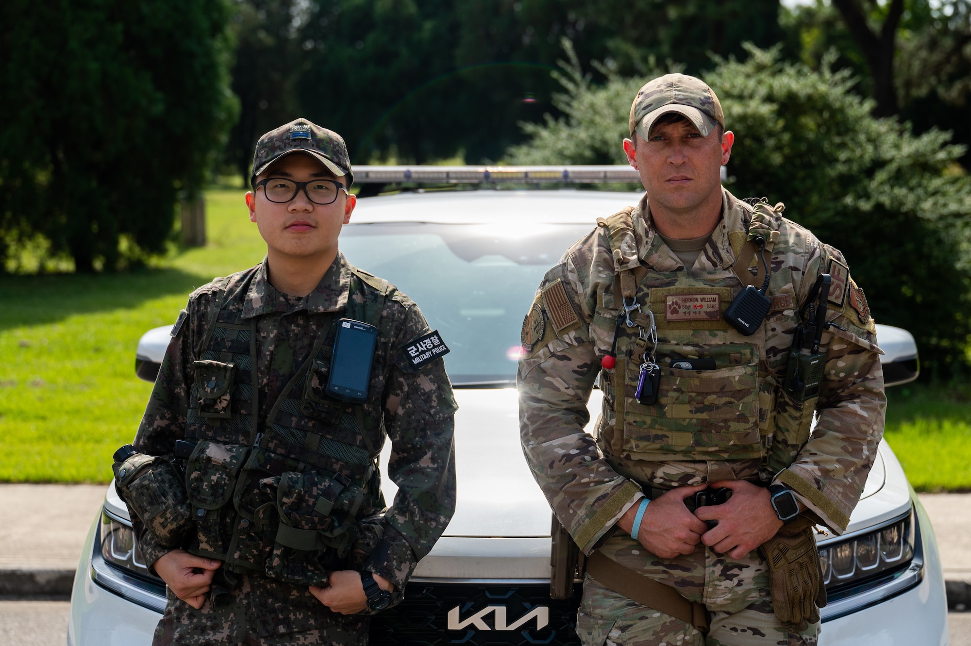 Republic of Korea Air Force Airmen 1st Class Huiseop Lin, left, and U.S. Air Force Staff Sgt. William Herron pose for a photo during the first-ever combined security patrol.