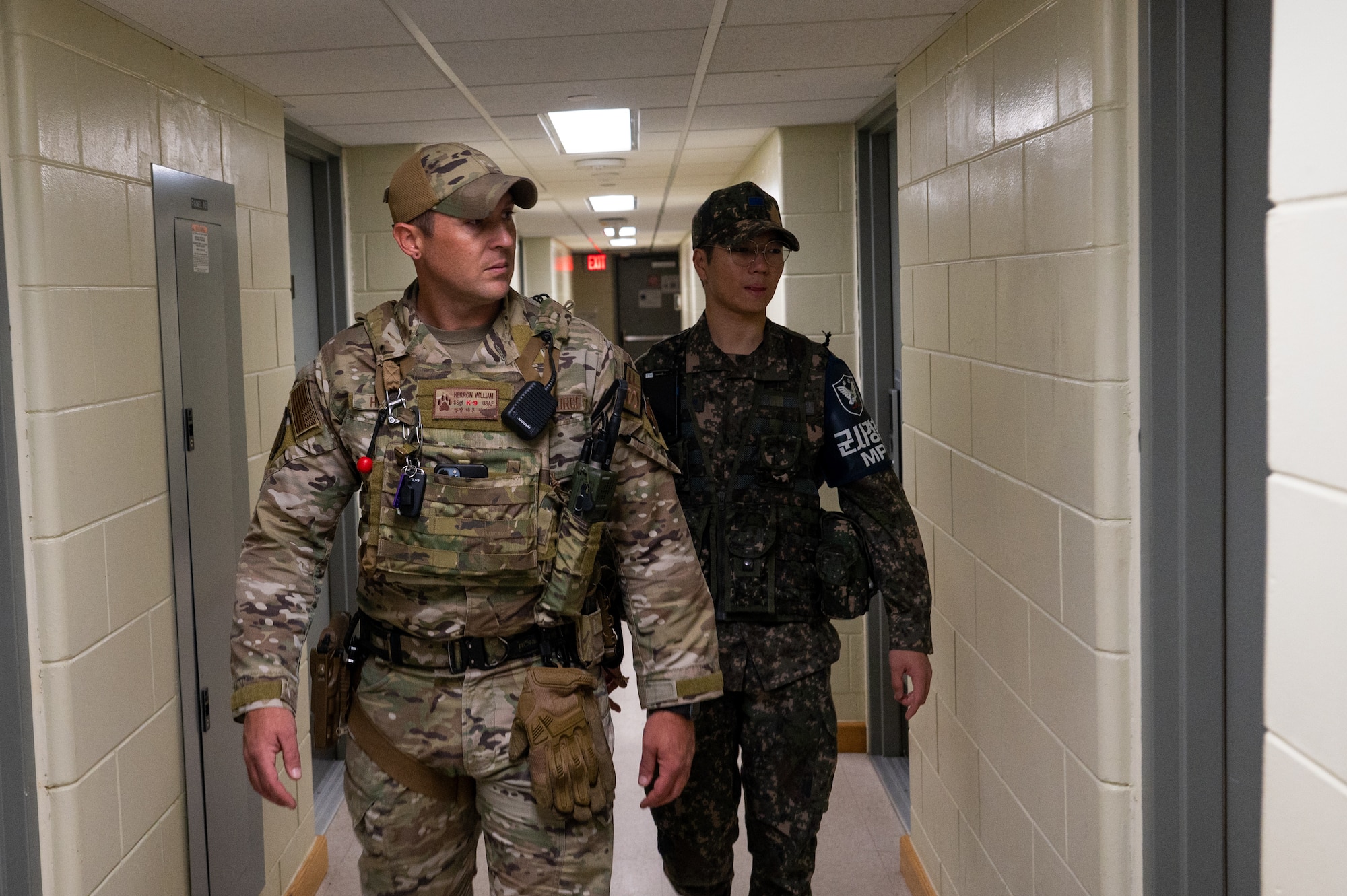 U.S. Air Force Staff Sgt. William Herron, 8th Security Forces Squadron patrolman, left, and Republic of Korea Air Force Airmen 1st Class Huiseop Lin patrol a dormitory building during the first-ever combined security patrols.