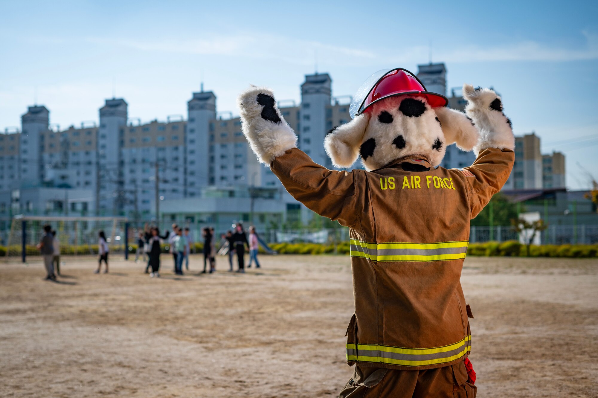 Sparky cheers on children at a soccer game during a Fire Prevention Week educational event.
