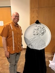 Daniel Lopez, 16th Air Force, Department of the Air Force Assessment and Authorization Branch, poses next to his great-great aunt Jovita Idar's coin for the 2023 American Women Quarters Program series, San Antonio, Sept. 16, 2023.