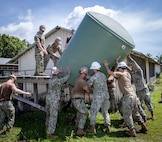 Seabees supporting Pacific Partnership 2023 remove a water container during a renovation project at Mongniol Primary School in Wewak, Papua New Guinea.