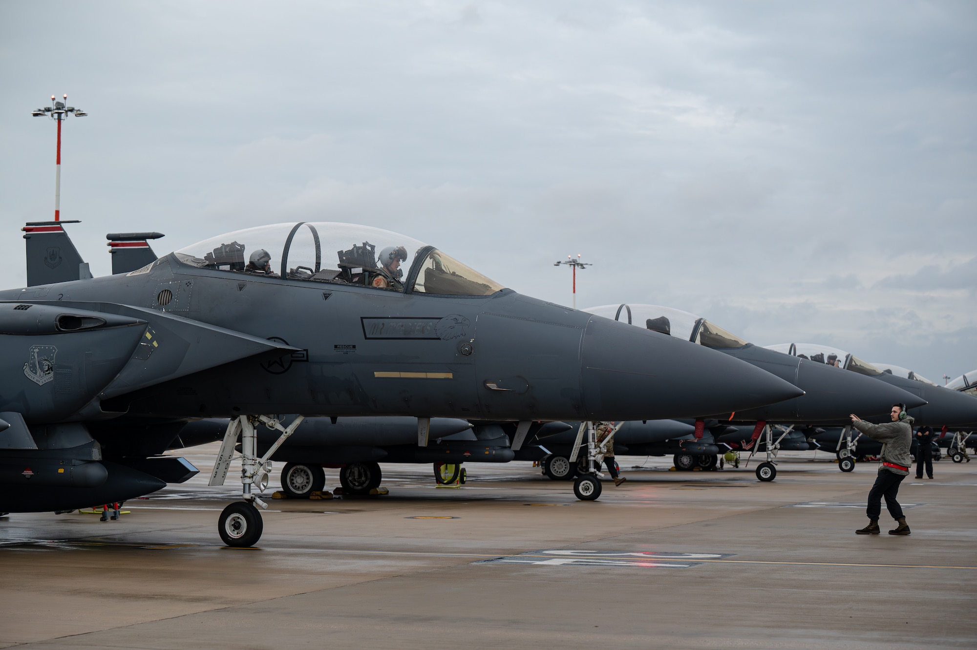 A U.S. Airman marshals an F-15E Strike Eagle aircraft