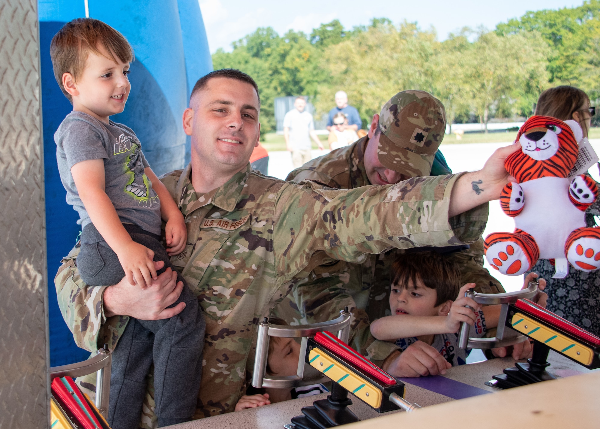 Staff Sgt. Joshua Jones, Air Transportation Supervisor for the 80th Aerial Port Squadron, wins a stuffed tiger for his son at a Dobbins Fall Festival game at Dobbins Air Reserve Base, Ga., Oct. 14, 2023. The annual event is an opportunity for service members to spend time with their dependents on base. (U.S. Air Force photo by Tech. Sgt. Joshua A. Kincaid)