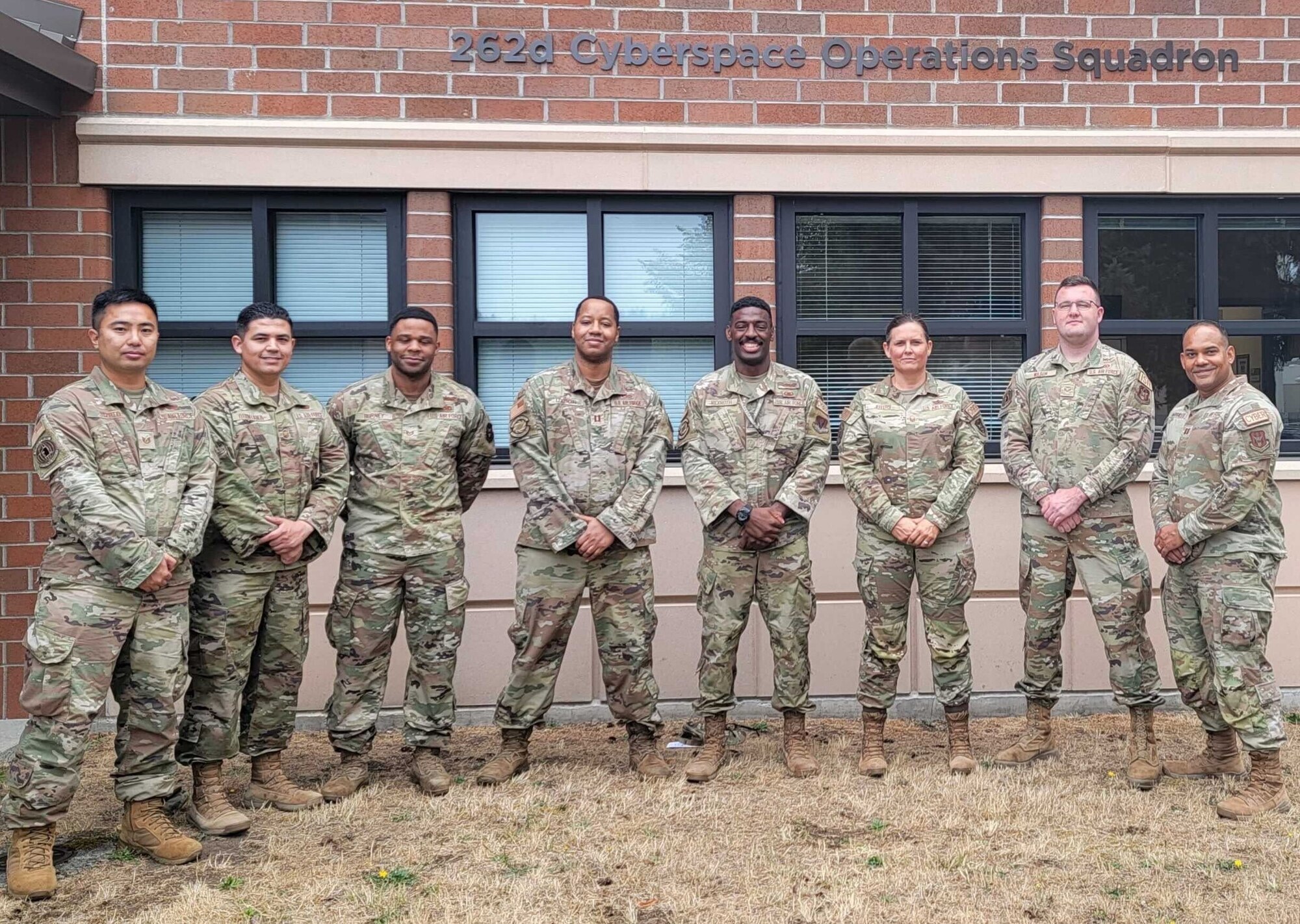Capts. Quenton Rexworth (center-right) and Kendall Dyson of the 143rd Cyber Operations Squadron pose with the 426 NWS members in front of the 262nd Cyberspace Operations Squadron headquarters at Joint Base Lewis-McChord, Washington on Sept. 1, 2023. (Courtesy photo)