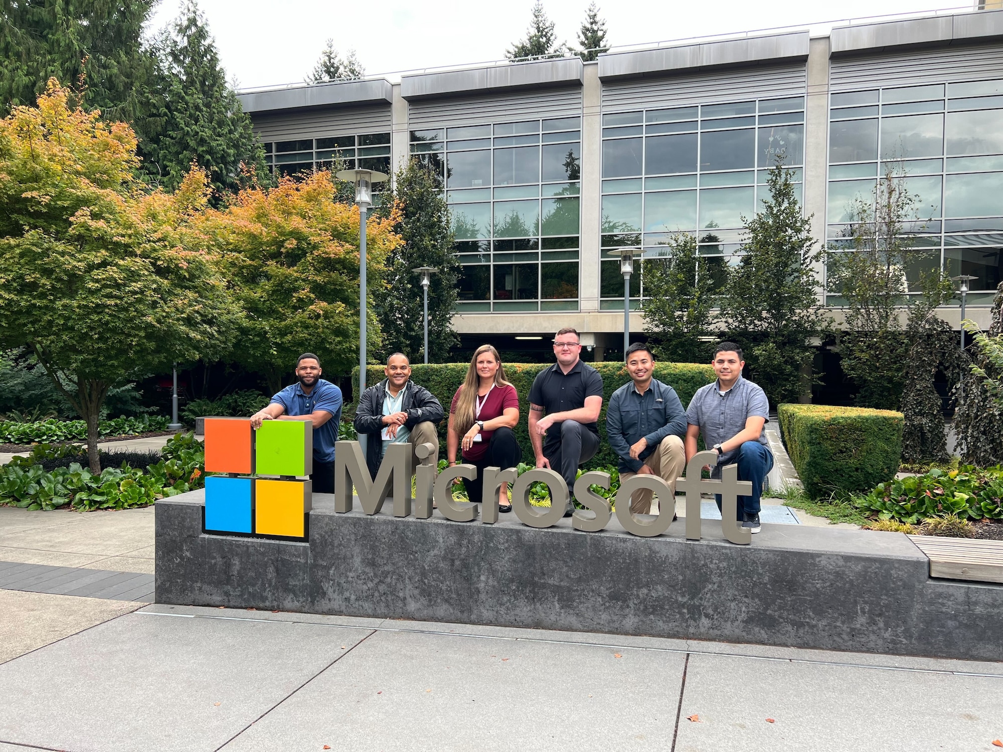 The 426 NWS team (left to right: TSgt Anthony Burney, Capt Rodolfo Morales, MSgt Andrienne Jeffers, SrA Jeremy Wilson, TSgt Wilson Szeto, and MSgt Mario Quintana) poses next to the corporation logo at Microsoft Corporation headquarters in Redmond, VA on Aug. 31, 2023. (Courtesy photo)