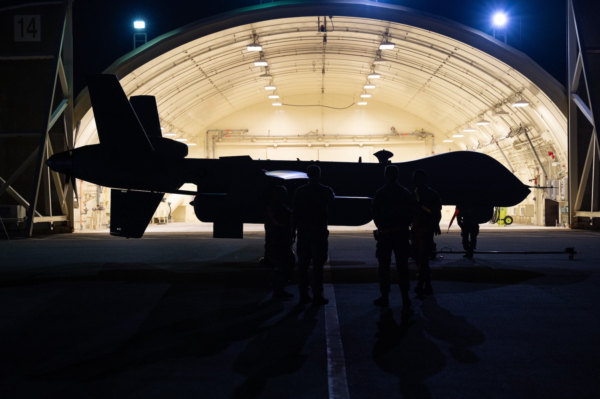 Airmen stand beside an aircraft.