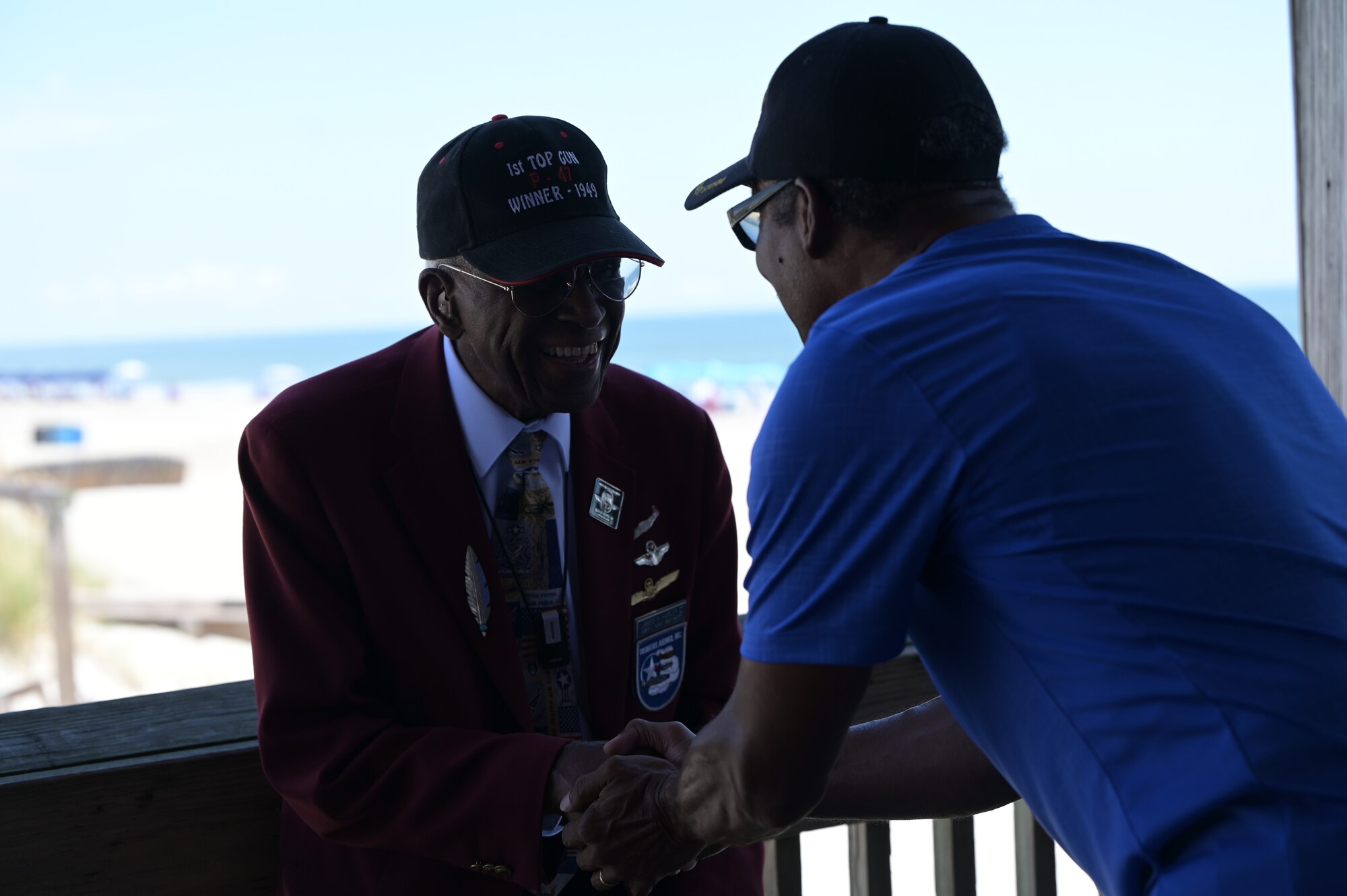 U.S. Air Force Lt. Col. James H. Harvey III, one of the original Tuskegee Airmen pilots with the 332nd Fighter Group, greets a U.S Army veteran, during a F-22 practice aerial demonstration, Sept. 13, 2023, at Tybee Island Beach, Georgia. This community event allowed residents of Savannah, Georgia and spectators of surrounding counties to be involved in the historic William Tell competition taking place at Savannah Air National Guard Base, Georgia. (U.S. Air National Guard photo by Senior Airman Christa Ross)