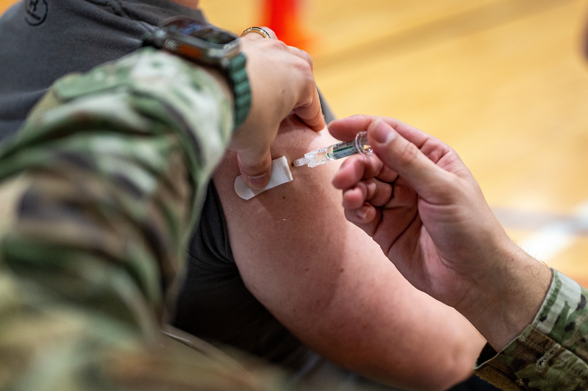 U.S. Air Force Tech. Sgt. Trevor Holley, 51st Health Care Operations Squadron noncommissioned officer in charge of primary care, vaccinates a patient during a public health emergency exercise at Osan Air Base, Republic of Korea, Oct. 12, 2023. The exercise allowed medics from the 51st Medical Group to flex their skills in mass prophylaxis capabilities. This training ensured that they can effectively distribute medications and vaccines to a large number of people during a public health crisis. Additionally, it offered a practical opportunity to administer mandatory flu vaccinations to Airmen. (U.S. Air Force photo by Staff Sgt. Thomas Sjoberg)