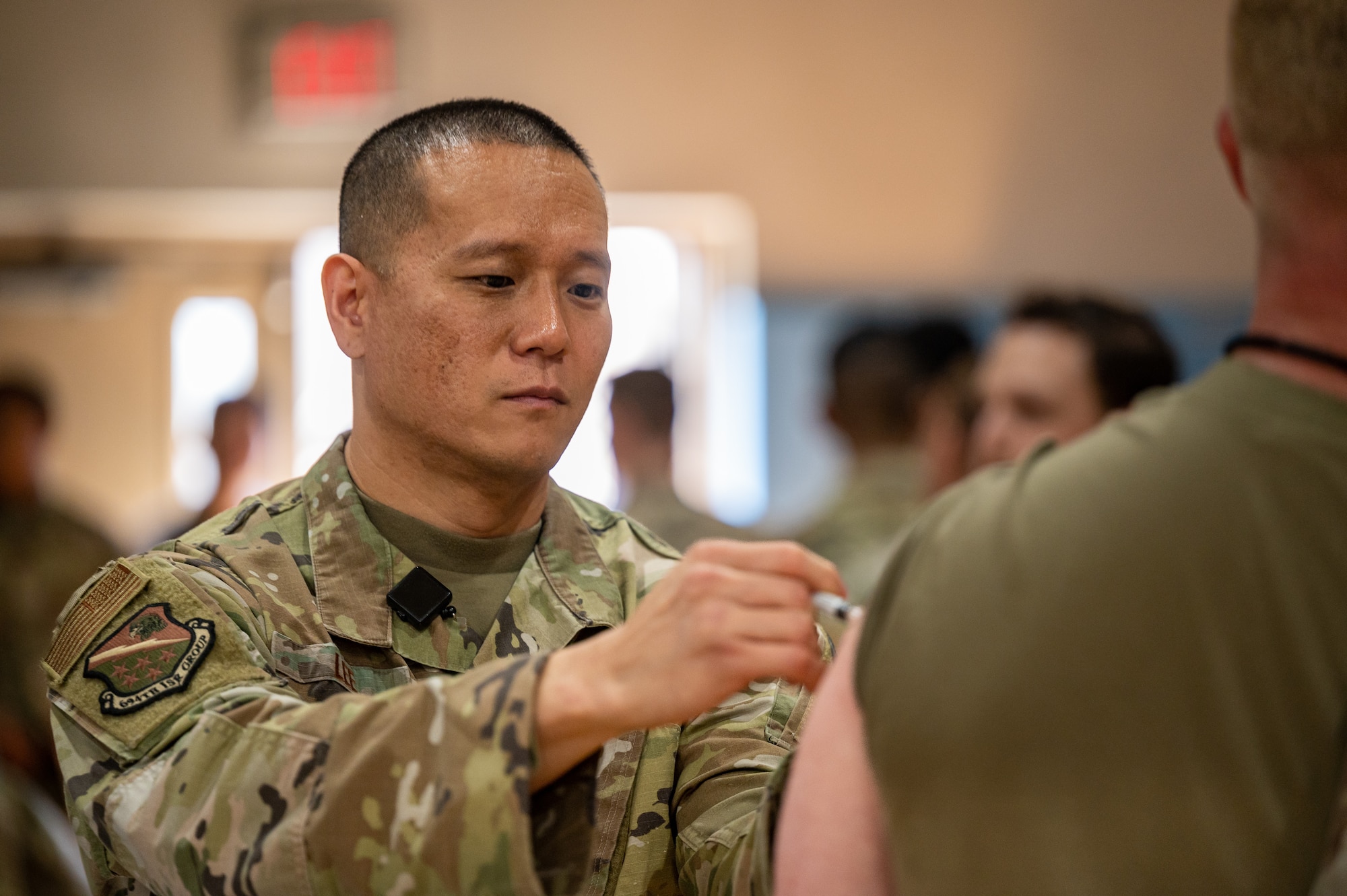 U.S. Air Force Master Sgt. Jin Lee, 694th Intelligence, Surveillance, and Reconnaissance Group medical technician, vaccinates an Airman during a public health emergency exercise at Osan Air Base, Republic of Korea, Oct. 12, 2023. The exercise enabled medics assigned to the  51st MDG to train on mass prophylaxis capabilities, which ensures efficient distribution of medications and vaccines to a large population during a public health emergency, while also providing Airmen with mandatory flu vaccinations. (U.S. Air Force photo by Staff Sgt. Thomas Sjoberg)