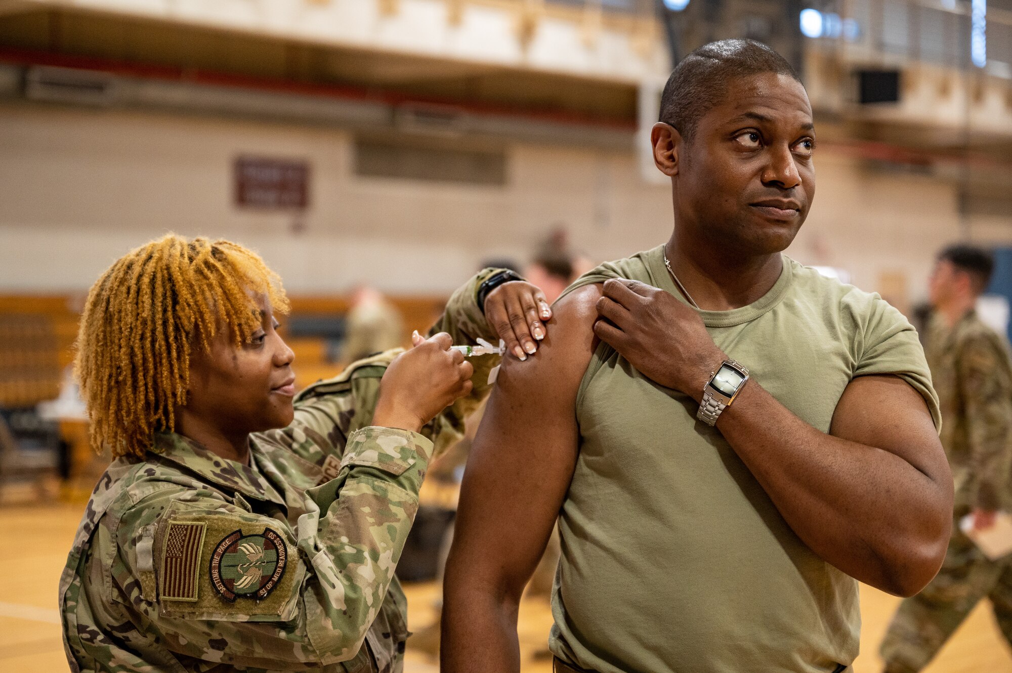 U.S. Air Force Tech. Sgt. Zsane Wrice, left, 51st Operational Medical Readiness Squadron flight medicine flight chief, vaccinates Lt. Col. Michael Newson, 51st Communications Squadron commander, during a public health emergency exercise at Osan Air Base, Republic of Korea, Oct. 12, 2023. The exercise empowered 51st Medical Group medics to hone their mass prophylaxis techniques, ensuring a rapid and efficient vaccination process for personnel during public health emergencies. Besides enhancing preparedness, active duty members, civilian personnel, and dependents were all administered their required vaccinations during the training. (U.S. Air Force photo by Staff Sgt. Thomas Sjoberg)