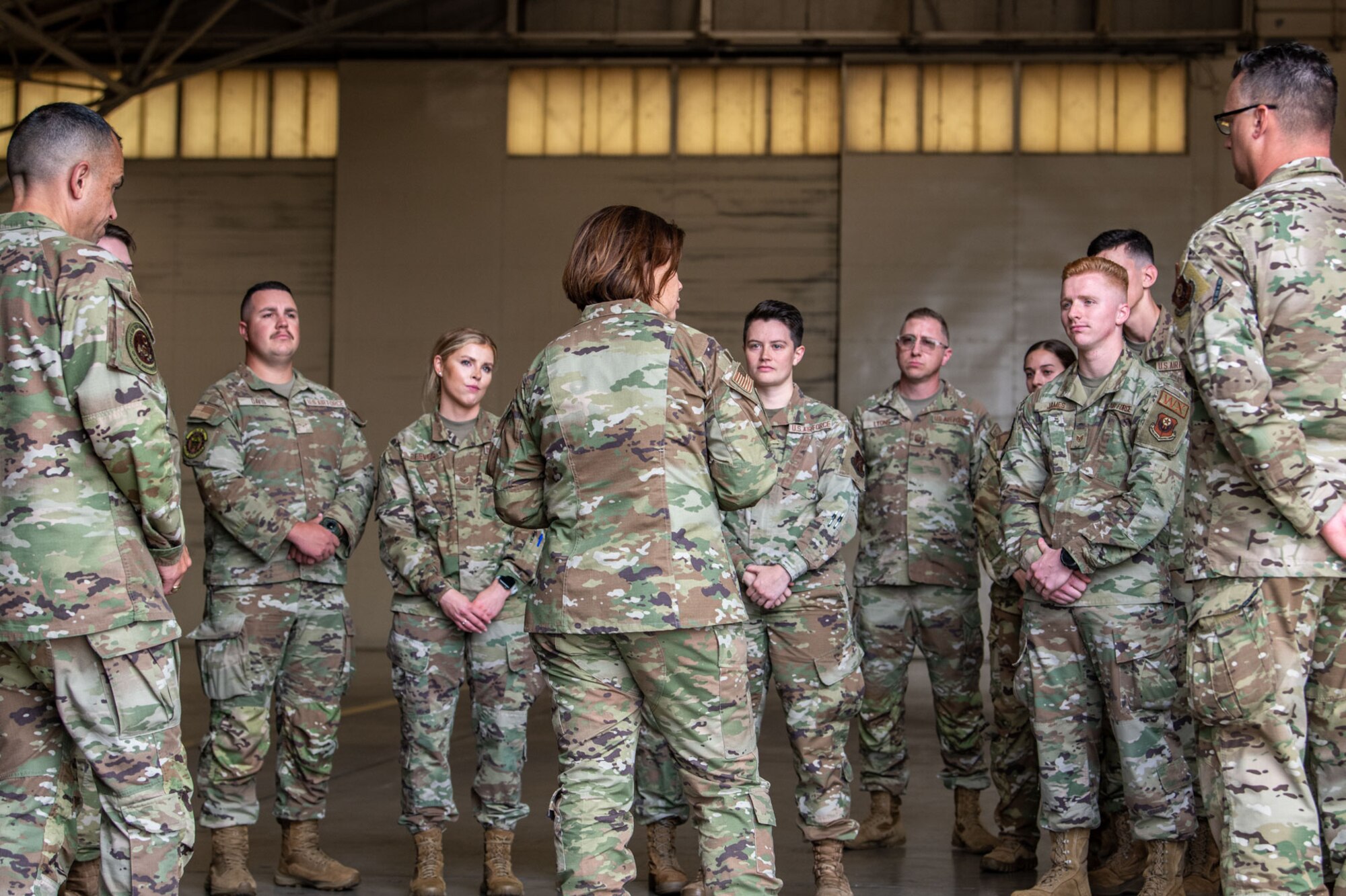 woman speaks to crowd of Airmen