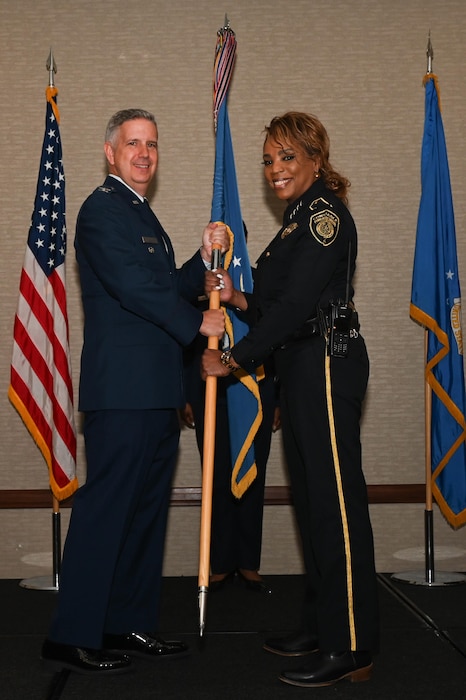 Col. Brenden Bartholomew, 433rd Airlift Wing vice commander, hands the 433rd AW guidon to Constable Kathryn Brown, Bexar County 4th Precinct constable, during the 433rd AW 2023 Honorary Commanders’ Induction Ceremony in San Antonio, May 6, 2023.