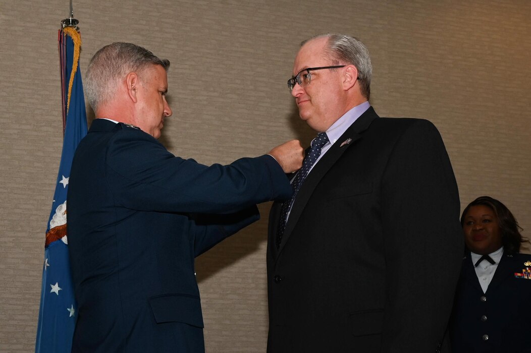 Col. Brenden Bartholomew, 433rd Airlift Wing vice commander, pins on the U.S. Air Force honorary commander insignia pin to Sean Grindall, USAA Life head of third-party distribution, at the 433rd AW 2023 Honorary Commanders’ Induction ceremony in San Antonio, May 6, 2023.