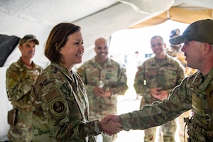 woman smiles as another woman speaks