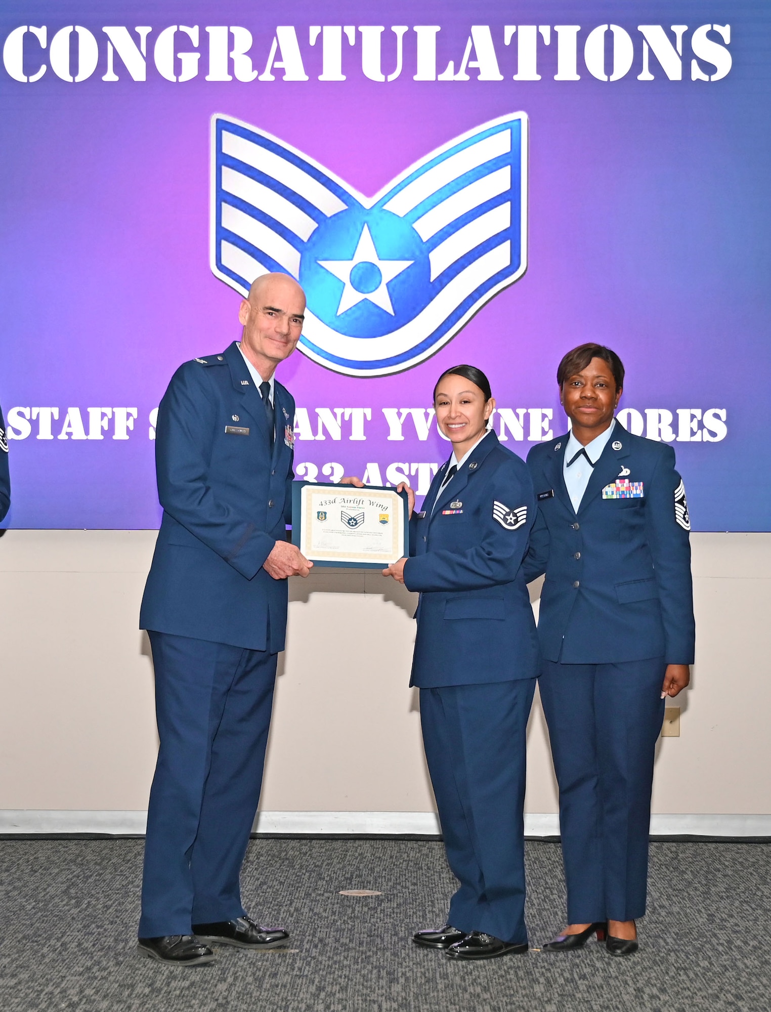 Staff Sgt. Yvonne Flores, 433rd Aeromedical Staging Squadron technician, accepts a certificate of induction from Col. William Gutermuth, 433rd Airlift Wing commander, during an NCO Induction Ceremony October 15, 2023, at Joint Base San Antonio-Lackland, Texas. (U.S. Air Force photo by Master Sgt. Samantha Mathison)
