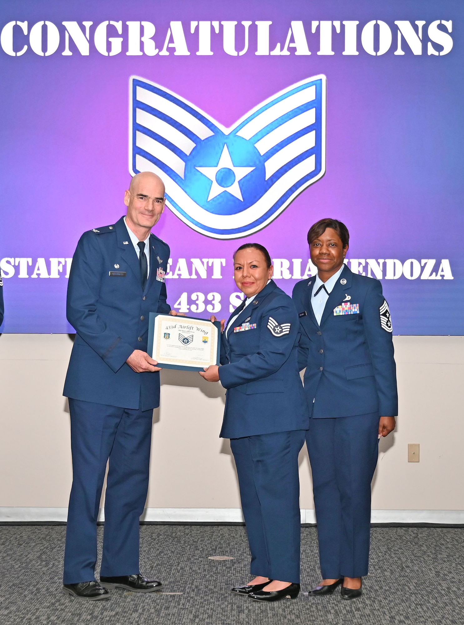 Staff Sgt. Maria Mendoza, 433rd Security Forces Squadron defender, accepts a certificate of induction from Col. William Gutermuth, 433rd Airlift Wing commander, during an NCO Induction Ceremony October 15, 2023, at Joint Base San Antonio-Lackland, Texas. (U.S. Air Force photo by Master Sgt. Samantha Mathison)