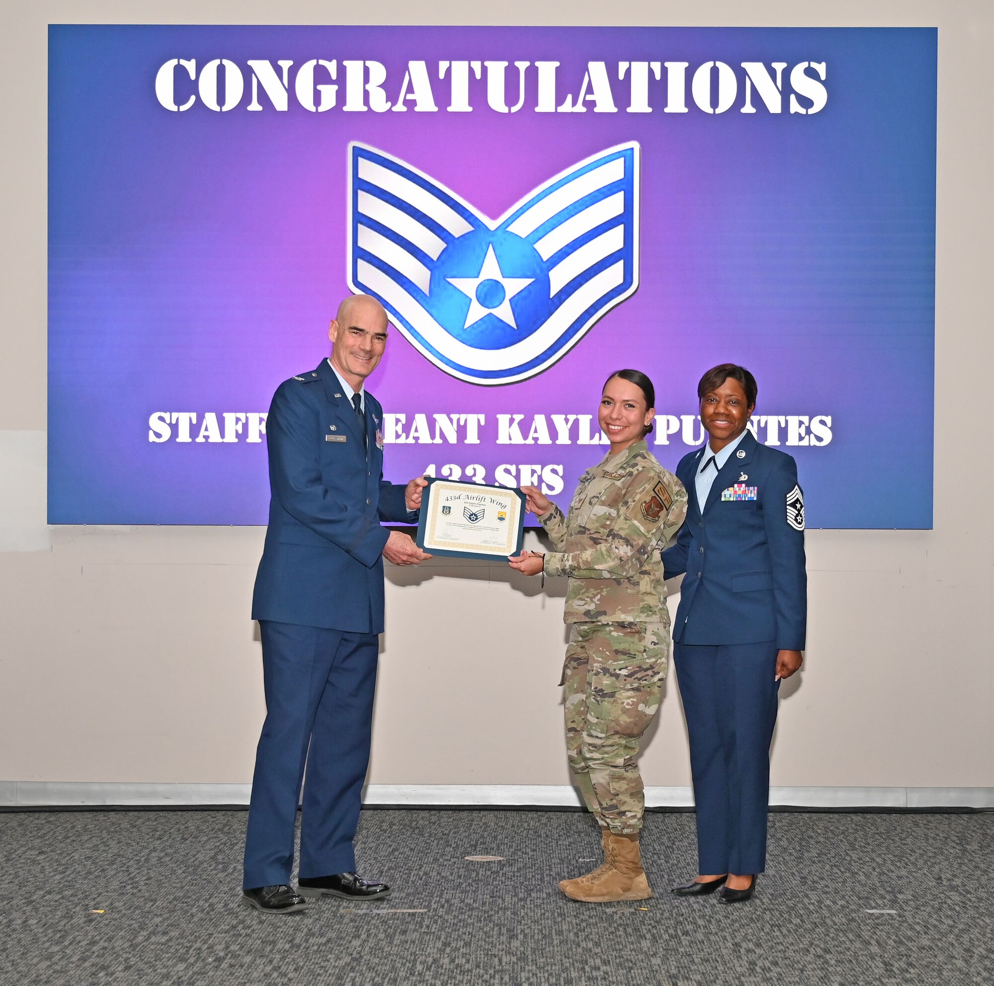 Staff Sgt. Kaylin Puentes, 433rd Security Forces Squadron defender, accepts a certificate of induction from Col. William Gutermuth, 433rd Airlift Wing commander, during an NCO Induction Ceremony October 15, 2023, at Joint Base San Antonio-Lackland, Texas. (U.S. Air Force photo by Master Sgt. Samantha Mathison)