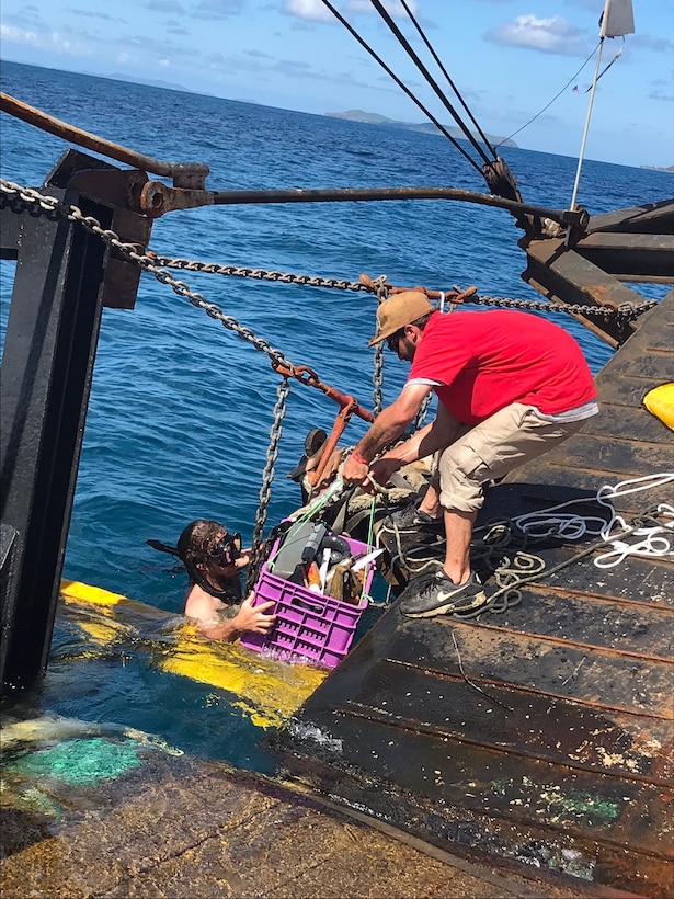 Salvors take collected debris from divers and bring it aboard the Bonnie G for disposal off Cyril E. King Airport, St. Thomas, Oct. 15, 2023. Divers removed approximately 2,500 lbs of debris from the ocean floor. (U.S. Coast Guard photo)