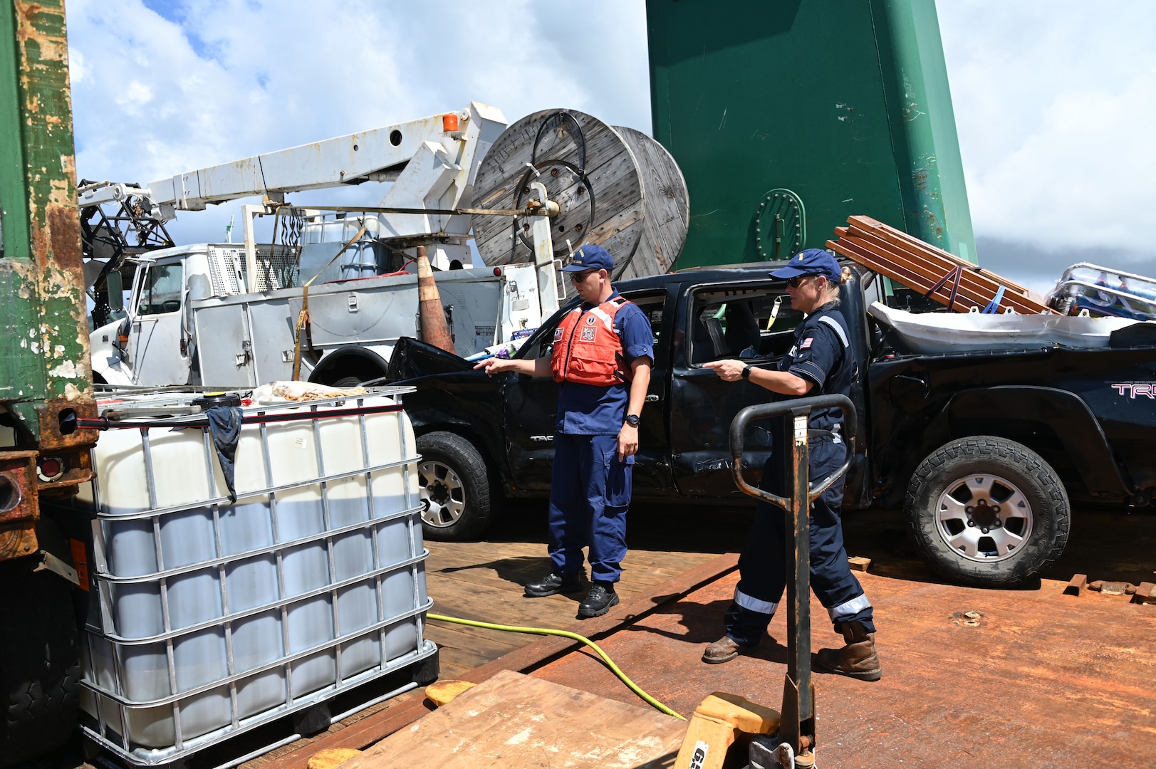 Coast Guard Incident Commander Lt. Cmdr. Christopher O'Conner is briefed by Chief Stefanie Daley, a marine science technician, on contained oil recovery operations on the Bonnie G off Cyril E. King Airport, St. Thomas, Oct. 14, 2023. The Bonnie G, a 195-foot Vanuatu-flagged “ro-ro” cargo vessel that grounded on Oct. 4 during Tropical Storm Philippe. (Coast Guard photo by Petty Officer 1st Class Nicole J. Groll)