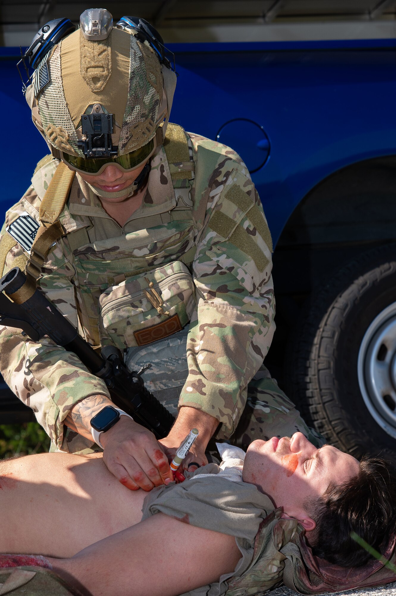 U.S. Air Force Capt. Austin LeMasters, 436th Civil Engineer Squadron Explosive Ordnance Disposal flight commander, applies triage to U.S. Air Force Airman 1st Class Caleb Moore, 436th CES EOD technician during a training session at Dover Air Force Base, Delaware, Oct. 13, 2023. LeMasters practiced rescuing a wounded individual from a vehicle while under simulated hostile fire and provided simulated advanced Tactical Combat Casualty Care. (U.S. Air Force photo by Roland Balik)