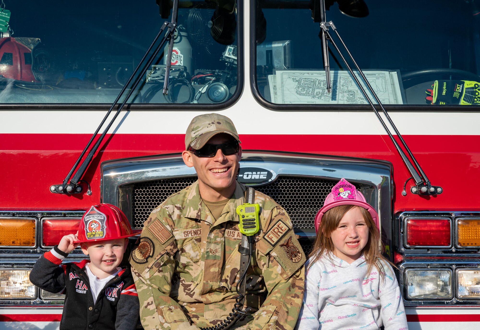 U.S. Air Force Staff Sgt. Kyle Spence, 436th Civil Engineer Squadron firefighter, poses with kids for a photo before the 2023 Fire Prevention Week Parade at Dover Air Force Base, Delaware, Oct. 13, 2023. Fire Prevention Week is a nation-wide observation that teaches people how to stay safe in case of a fire. (U.S. Air Force photo by Airman 1st Class Amanda Jett)