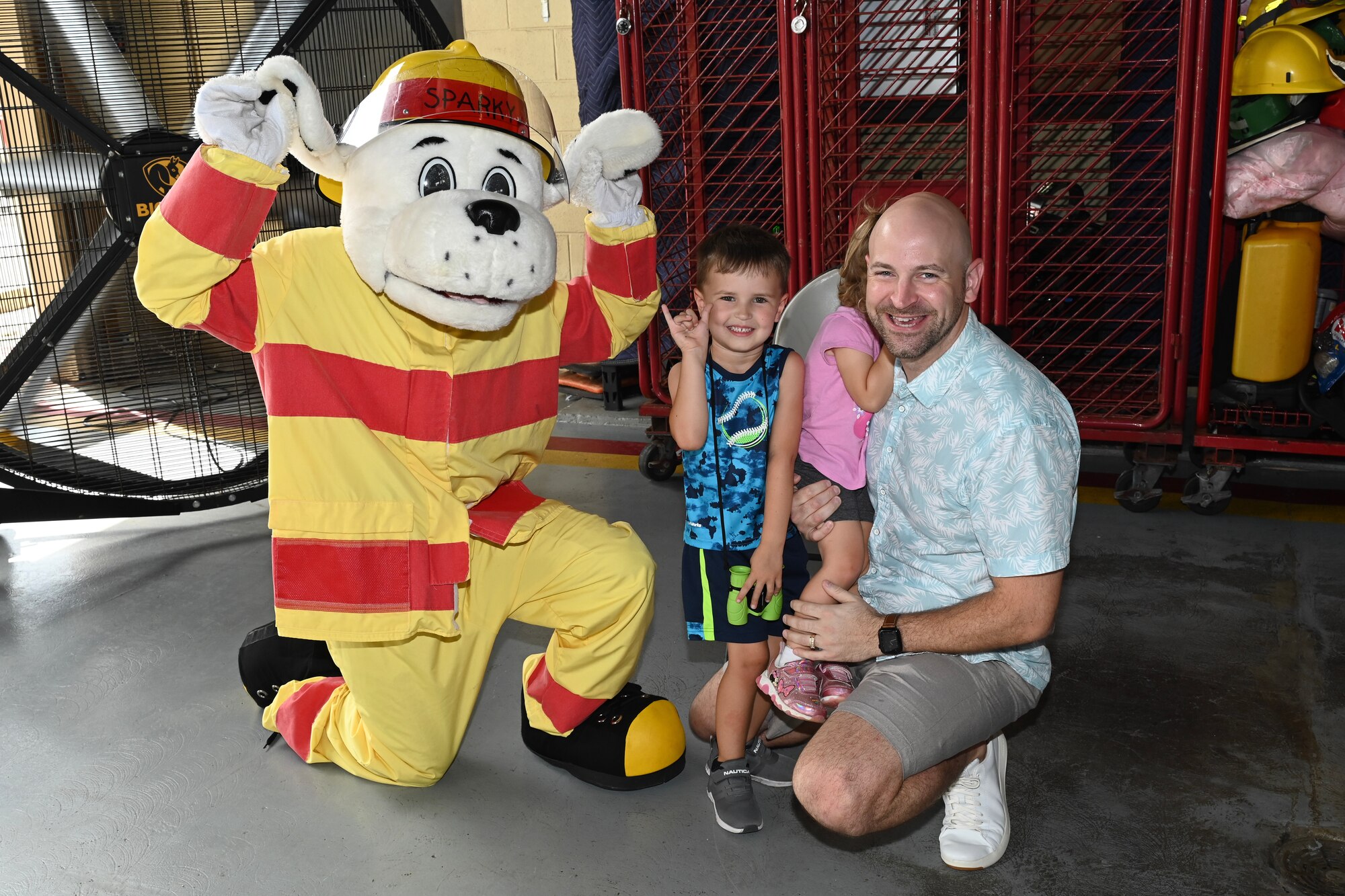 Sparky the Fire Dog poses for a photo with a military family.