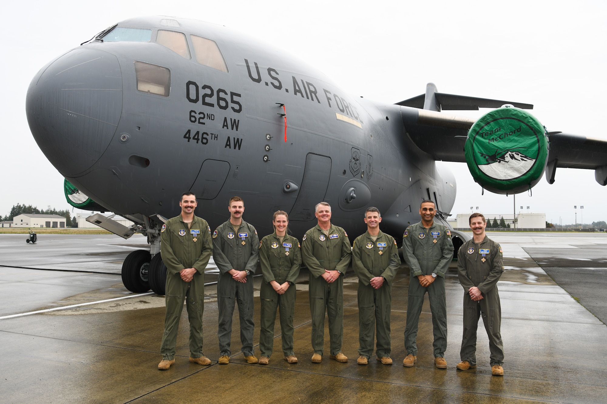 A group of people in flight suits standing in front of a C-17 Globemaster III.