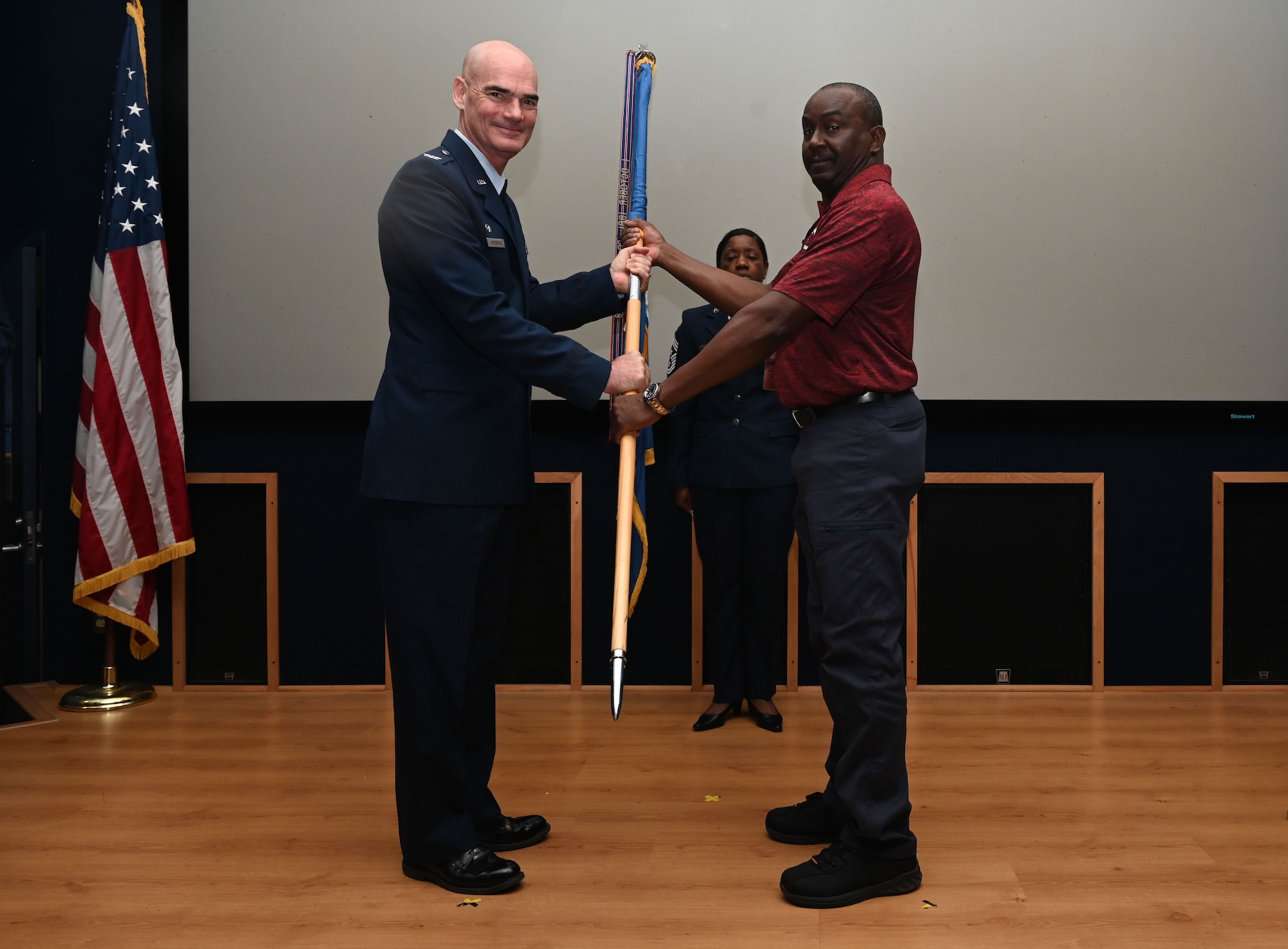Col. William Gutermuth, 433rd Airlift Wing commander, hands the 433rd AW guidon to Larry McHenry, Chief Executive Office for Power Grid Professional Incorporated, during the Honorary Commanders’ Induction Ceremony on Joint Base San Antonio-Lackland, Texas, Oct. 15, 2023. Honorary commanders have opportunities to learn about their units and commanders through C-5M Super Galaxy tours, demonstrations, events and flights.