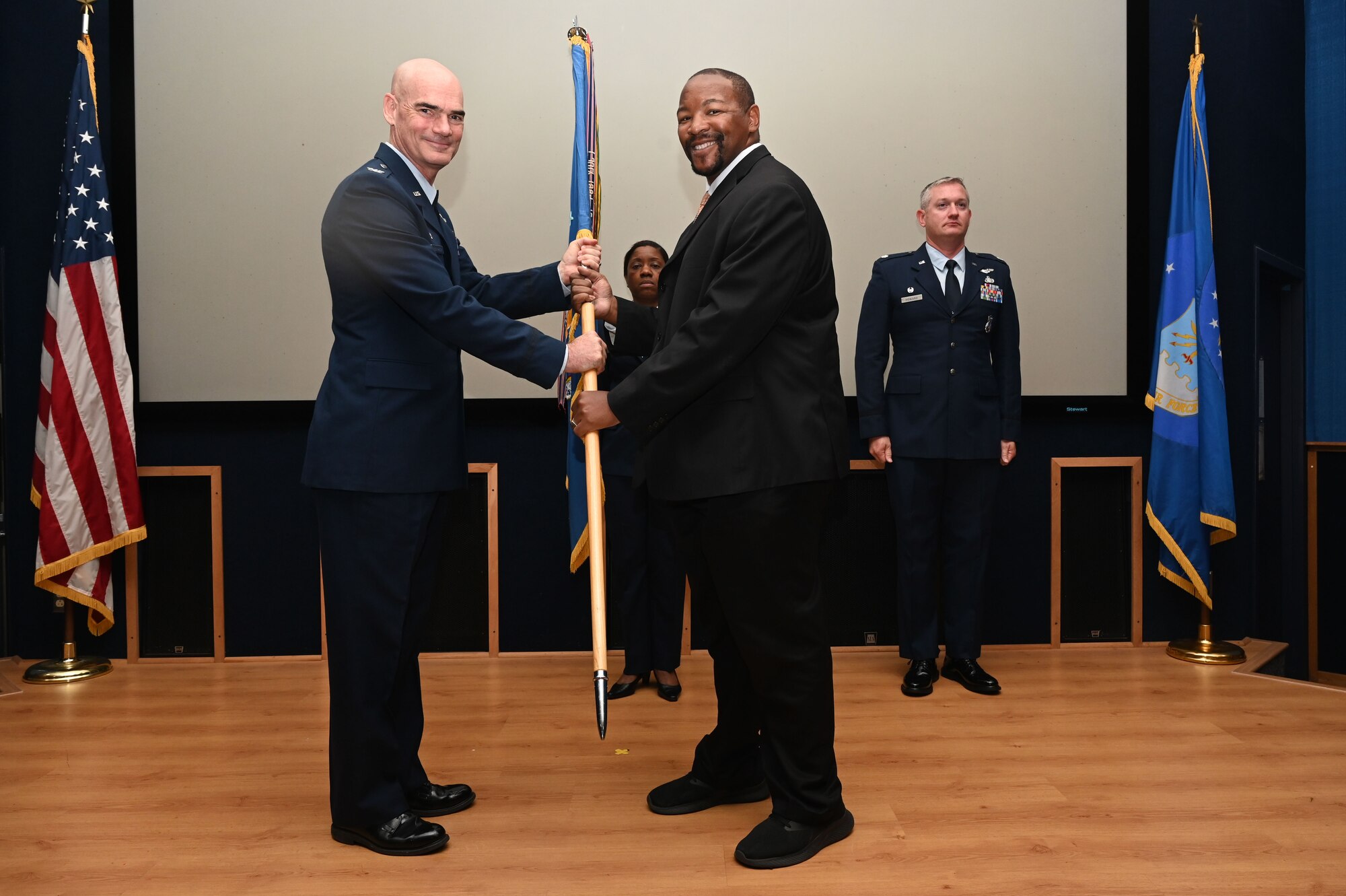 Col. William Gutermuth, 433rd Airlift Wing commander, hands the 433rd AW guidon to Darnell Smith, inaugural director of intercollegiate athletics for Texas A&M University-San Antonio, Texas, during the Honorary Commanders’ Induction Ceremony on Joint Base San Antonio-Lackland, Oct. 15, 2023. Honorary commanders have opportunities to learn about their units and commanders through C-5M Super Galaxy tours, demonstrations, events and flights.