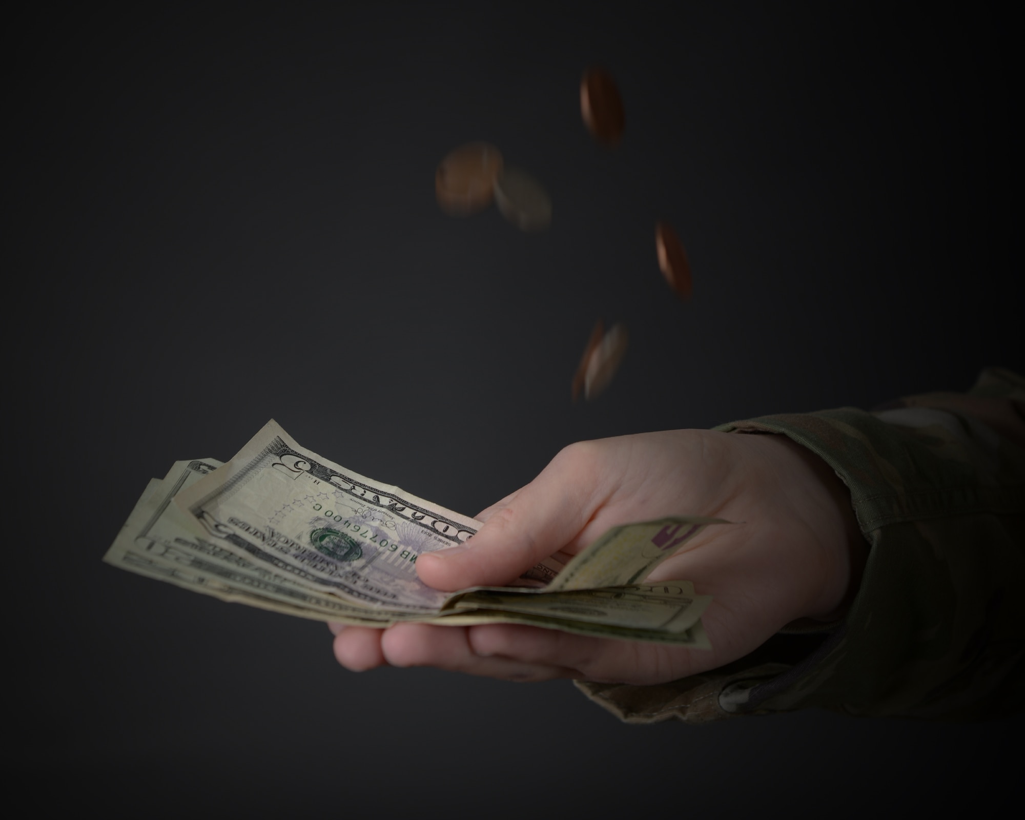 An Airman lets a stack of coins fall into the palm of their hand in honor of Financial Planning Month at Laughlin Air Force Base, Texas, Oct. 13, 2023. 47th Force Support Squadron financial advisors provide Airmen with information, education, and personal financial training to assist them in achieving financial stability. (U.S. Air Force photo by Airman 1st Class Kailee Reynolds)